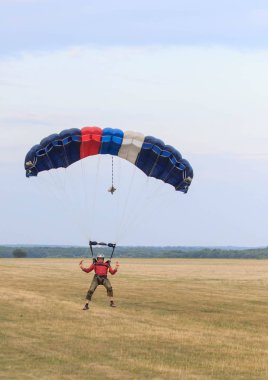 Sutiski, Ukrayna - 24 Haziran 2017: Skydivers iniş sonra bir paraşüt taşır. Skydive Ukrayna olduğunu Sutiski Aerodrome yaklaşık 20 km Vinitsa, Ukrayna'nın güneybatısında bulunan havadalışı Merkezi.