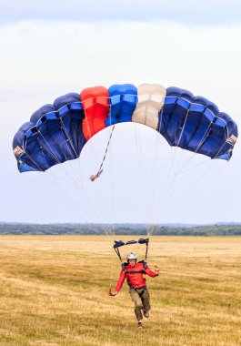 Sutiski, Ukrayna - 24 Haziran 2017: Skydivers iniş sonra bir paraşüt taşır. Skydive Ukrayna olduğunu Sutiski Aerodrome yaklaşık 20 km Vinitsa, Ukrayna'nın güneybatısında bulunan havadalışı Merkezi.