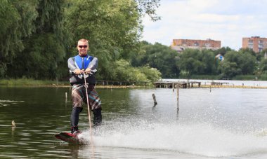 Vatutine, Ukrayna - 15 Temmuz: Atlet wakeboarding ve bir noktada hileci üzerinde 15 Haziran 2017 Vatutine, Ukrayna'da teknik direktör