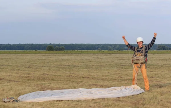 Sutiski, Ucrania - 24 de junio de 2017: Los paracaidistas llevan un paracaídas después del aterrizaje. Skydive Ucrania es el centro de paracaidismo situado en el aeródromo de Sutiski, a unos 20 km al suroeste de Vinitsa, Ucrania . — Foto de Stock