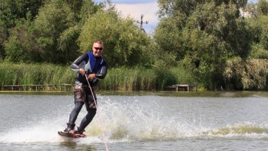 Vatutine, Ukrayna - 15 Temmuz: Atlet wakeboarding ve bir noktada hileci üzerinde 15 Haziran 2017 Vatutine, Ukrayna'da teknik direktör