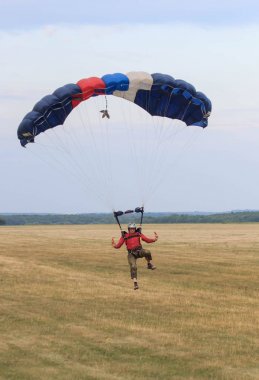 Sutiski, Ukrayna - 24 Haziran 2017: Skydivers iniş sonra bir paraşüt taşır. Skydive Ukrayna olduğunu Sutiski Aerodrome yaklaşık 20 km Vinitsa, Ukrayna'nın güneybatısında bulunan havadalışı Merkezi.