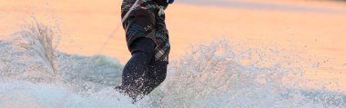 Yaz aylarında göl kenarında bir wakeboard üzerinde erkek atlet rides