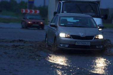 Shpola, Ukrayna - 28 Temmuz 2017: Otomobil sürüş su dolu bir yolda Shpola, şiddetli yağmur nedeniyle bir sel sırasında