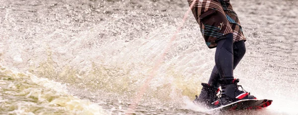 Atleta masculino monta em um wakeboard no lago no verão — Fotografia de Stock