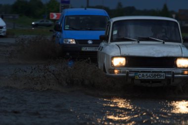 Shpola, Ukrayna - 28 Temmuz 2017: Otomobil sürüş su dolu bir yolda Shpola, şiddetli yağmur nedeniyle bir sel sırasında