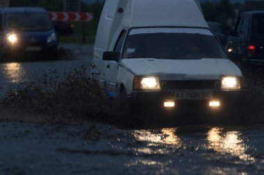 Shpola, Ukrayna - 28 Temmuz 2017: Otomobil sürüş su dolu bir yolda Shpola, şiddetli yağmur nedeniyle bir sel sırasında