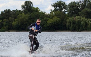 Vatutine, Ukrayna - 15 Temmuz: Atlet wakeboarding ve bir noktada hileci üzerinde 15 Haziran 2017 Vatutine, Ukrayna'da teknik direktör