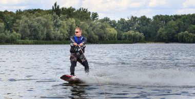 Vatutine, Ukrayna - 15 Temmuz: Atlet wakeboarding ve bir noktada hileci üzerinde 15 Haziran 2017 Vatutine, Ukrayna'da teknik direktör