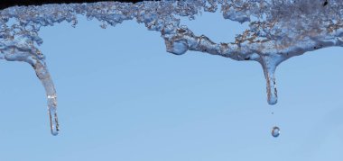 Su ile beyaz köpüklü buz sarkıtları aşağı asılı buz düşer