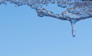 Su ile beyaz köpüklü buz sarkıtları aşağı asılı buz düşer