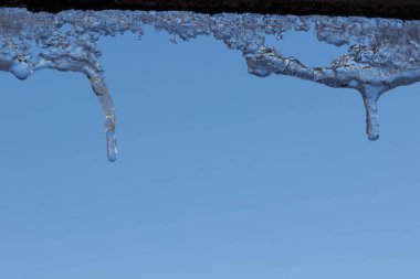 Su ile beyaz köpüklü buz sarkıtları aşağı asılı buz düşer