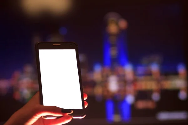 Kobieta za pomocą swojego telefonu komórkowego w ulicy, noc światła nieostrość obrazu tła — Zdjęcie stockowe