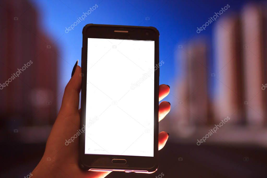 Woman using her Mobile Phone in the street, night light Background soft focus picture