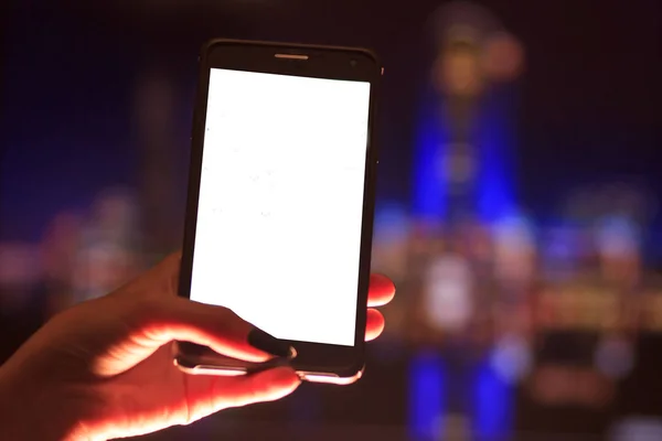 Kobieta za pomocą swojego telefonu komórkowego w ulicy, noc światła nieostrość obrazu tła — Zdjęcie stockowe