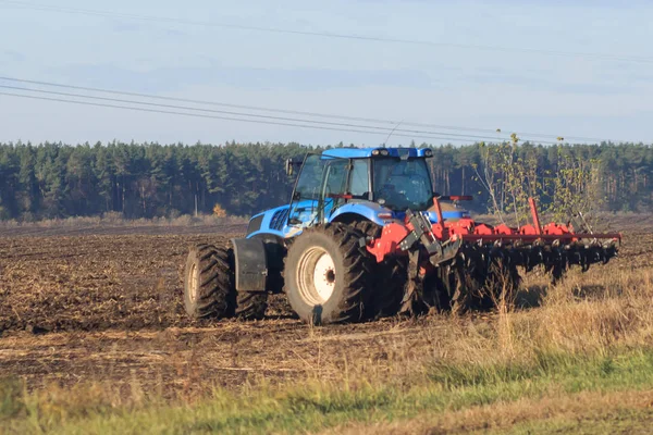 Farmer with tractor seeding - sowing crops at agricultural fields in spring — Stock Photo, Image