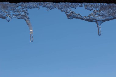 Su ile beyaz köpüklü buz sarkıtları aşağı asılı buz düşer