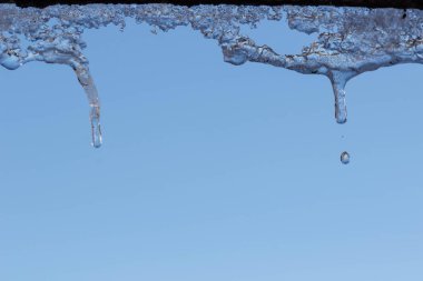 Su ile beyaz köpüklü buz sarkıtları aşağı asılı buz düşer