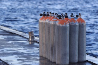 Hava tankları ahşap platformda tüplü dalış için dalış kulübü Maldivler beyaz kum plaj yakınındaki. Güzel gün batımı.