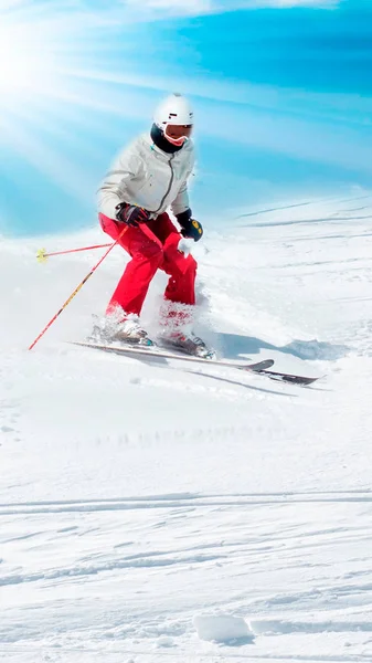 Vrouwelijke skiër afdaling met zon en bergen. — Stockfoto