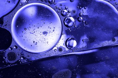 Soyut klasik mavi yağ damlaları bir su yüzeyine düşer