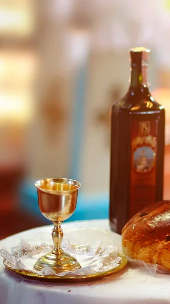 Holy communion on wooden table on church. Cup of glass with red wine, bread on wooden table. Holy Bible