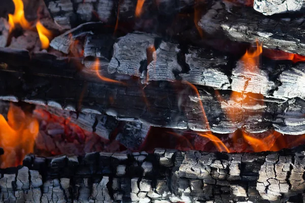 Gloeiende hete houtskool in BBQ Grill pit met vlammen achtergrond textuur, close-up — Stockfoto