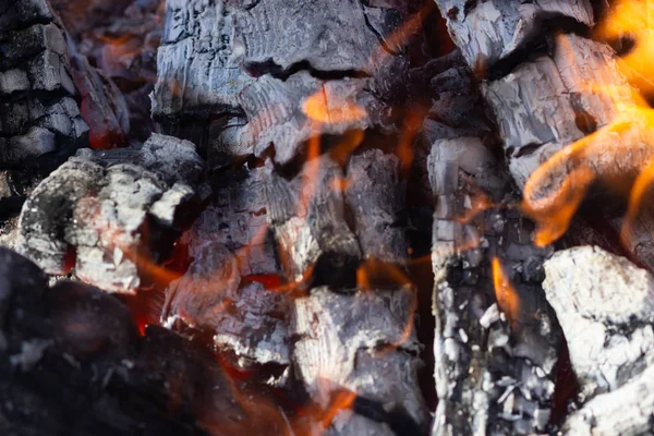 Brillante carbón caliente en barbacoa parrilla con llamas fondo textura, primer plano —  Fotos de Stock
