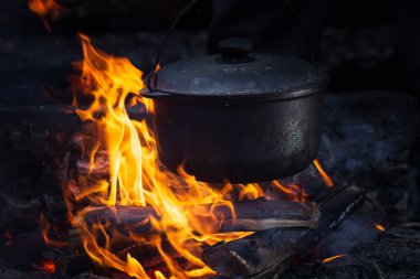 Kamp ateşinde yemek hazırlıyorum. Doldur.