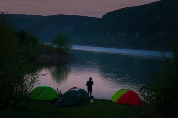 Mystical night landscape, in the foreground hike, campfire and tent