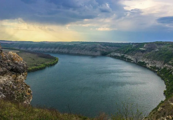 Panoramic view from the hill on bend of the river. Beautiful summer landscape. Colorful clouds of the morning sky. Dniester Canyon located at the territory of Dniester River Valley in Ukraine.