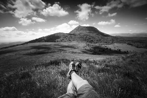 Puy de Dome mountain and hikers legs, Auvergne