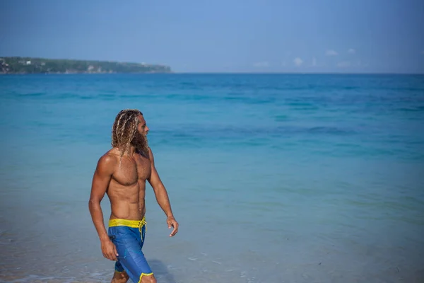 Halblanges Porträt eines gut aussehenden, muskulösen, bärtigen, lockigen blonden Mannes mit nacktem Oberkörper, der am Ozean entlang läuft — Stockfoto
