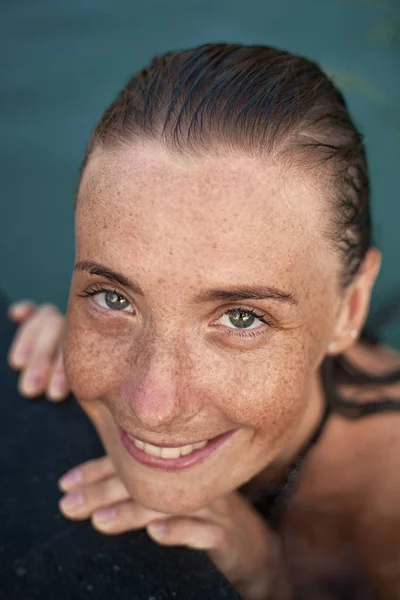 Retrato vertical de cerca de una hermosa chica con pecas y cabello mojado en agua — Foto de Stock