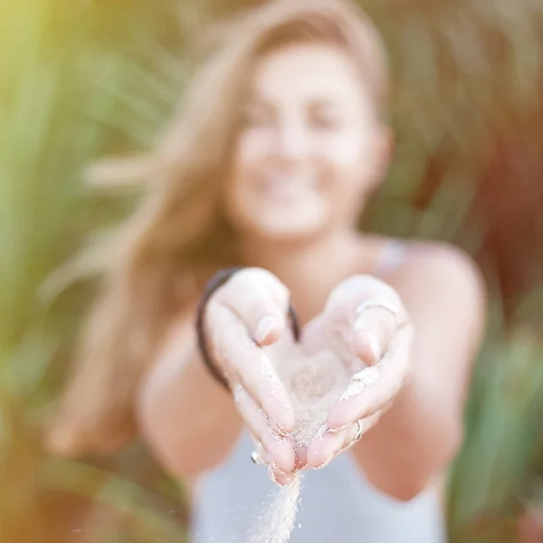 Ręce z białym piaskiem z piękną kobietą. Obraz kwadratowy — Zdjęcie stockowe