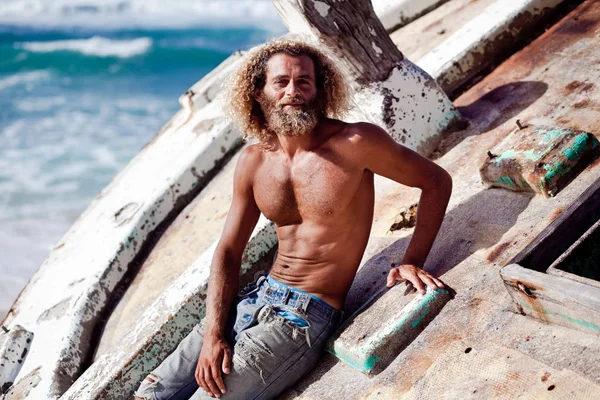 Robinson Crusoe. El hombre de barba rizada se apoya en los restos . —  Fotos de Stock