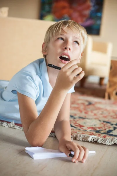 Sarışın genç çocuk odada kağıttan bir uçakla yerde yatıyor, elinde bir kalem tutuyor. Adam rüyasında, ağzı açık bir şekilde uzaklara bakıyor.