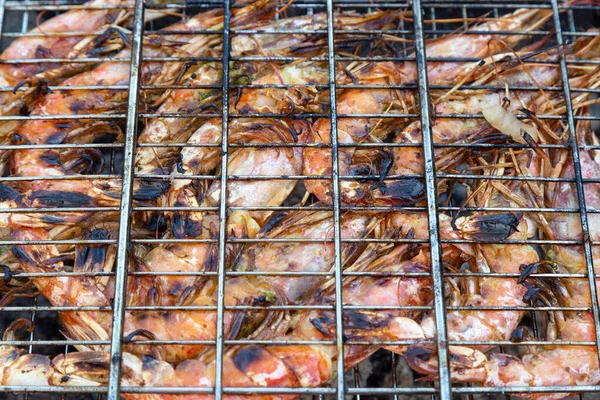 Zbliżenie - się duże różowe krewetki langoustines z karapaksem leżą na grillu. Pieczeń — Zdjęcie stockowe