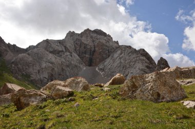 Kaya, gökyüzü ve çim