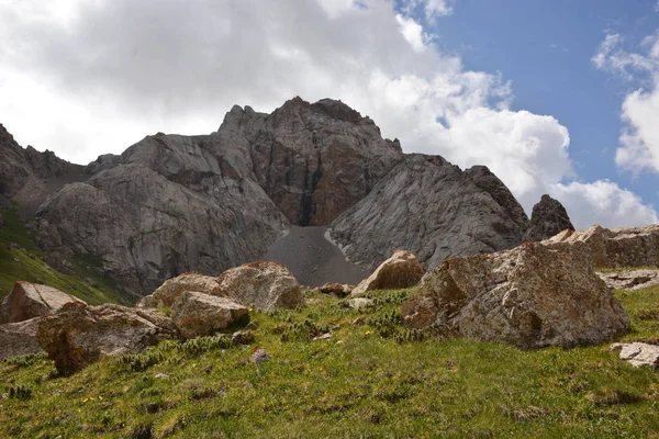 Kaya, gökyüzü ve çim