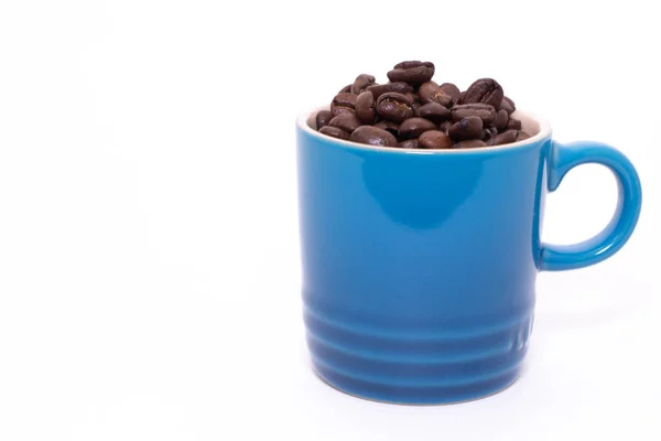 Coffee mug filled up with coffee beans — Stock Photo, Image