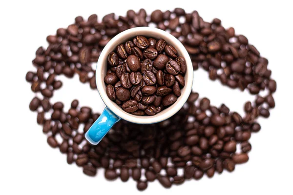 Kształt ziarna kawy stworzony z ziaren kawy i kubek — Zdjęcie stockowe