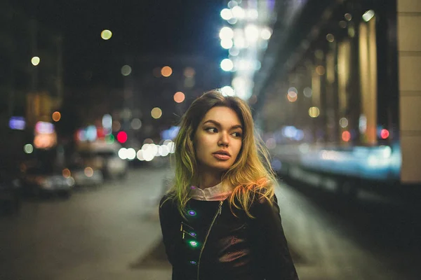 Linda chica en el fondo de las calles de la ciudad. La modelo parece a un lado. Imagen de un plan general. Efecto de película en postproducción . —  Fotos de Stock