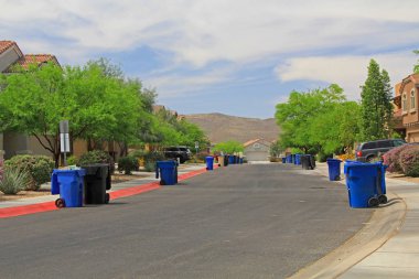 Mavi çöp kutularını cadde üzerinde çöp günü mavi gökyüzü kopya alanı ile bir Tucson mahallede kuyruğu.