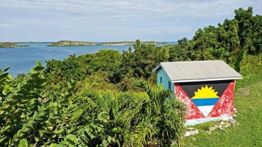 Mercer Koyu, Mevsimler, Antigua Barbuda Küçük Antiller, Batı Hint Adaları, Karayipler 'e bakan Antigua Bayrağı ile boyanmış..