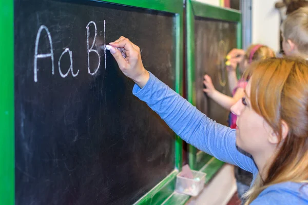 Learning to write ABC on the blackboard — Stock Photo, Image