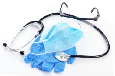 Virüs salgını sırasında koruyucu tıbbi ekipman kavramı - cerrahi maske, gözlük, stetoskop ve tıbbi eldiven.