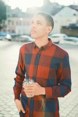 adam modern şehir arka plan üzerinde duran içki ile