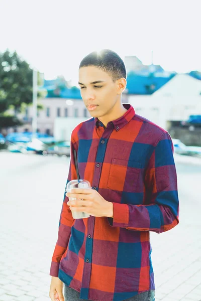 man with drink standing on modern city background