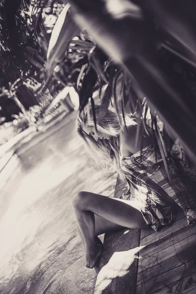 Jonge vrouw zitten in de buurt van zwembad — Stockfoto